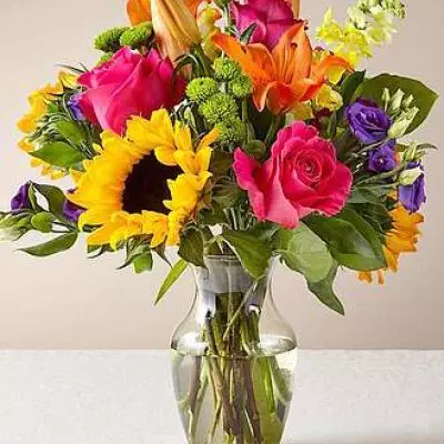 The Best Day™ Bouquet is ready to create a moment your recipient will always remember! An instant mood booster with it's mix of bright bold colors, this gorgeous fresh flower arrangement brings together sunflowers, hot pink roses, purple double lisianthus, orange LA Hybrid Lilies, yellow snapdragons, green button poms, and lush greens to make this day, their best day. Presented in a clear glass vase, this fresh flower arrangement is made just for you to help you send your warmest birthday, congratulations, or get well wishes to your favorite friends and family.